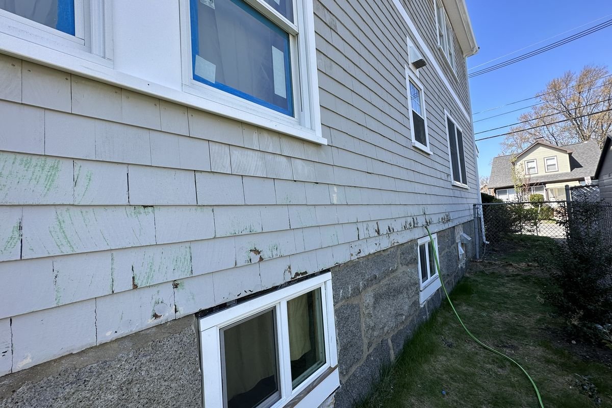 Weathered home exterior with peeling paint before repaint