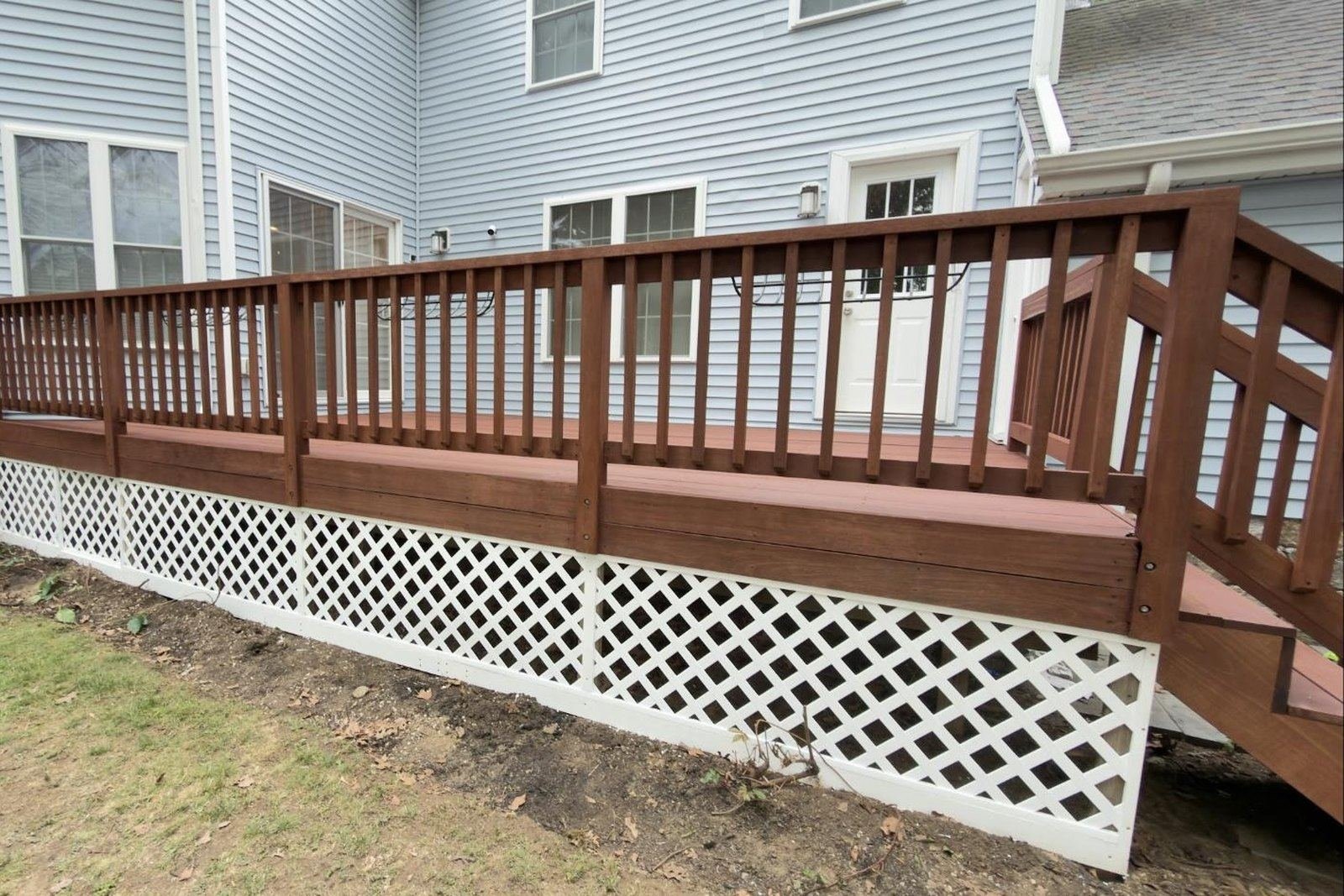 Backyard deck after restoration with a warm mahogany stain and fresh white lattice