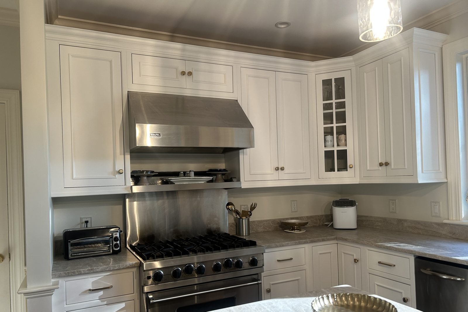 Kitchen range wall with cabinets refinished in a crisp hand painted white