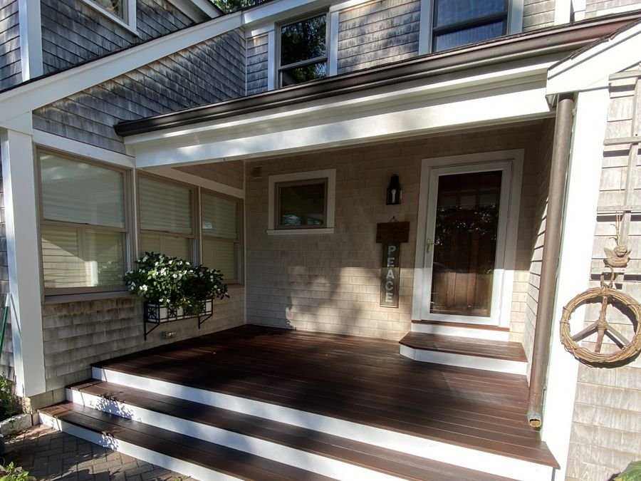 Coastal entry porch with white trim and dark deck