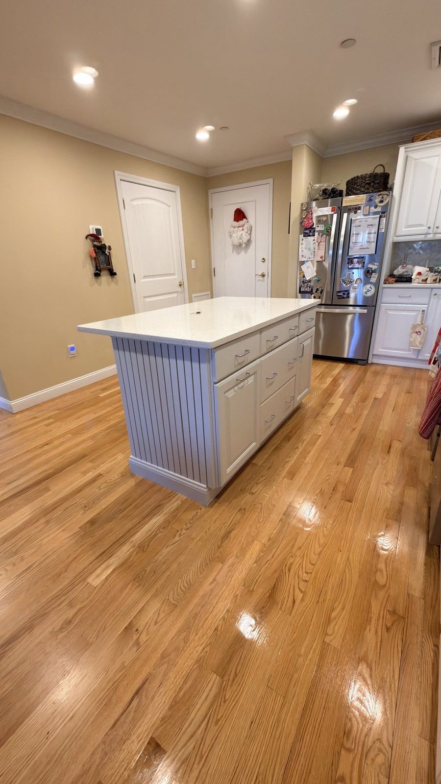 Kitchen with a white painted island and a full run of refinished cabinets