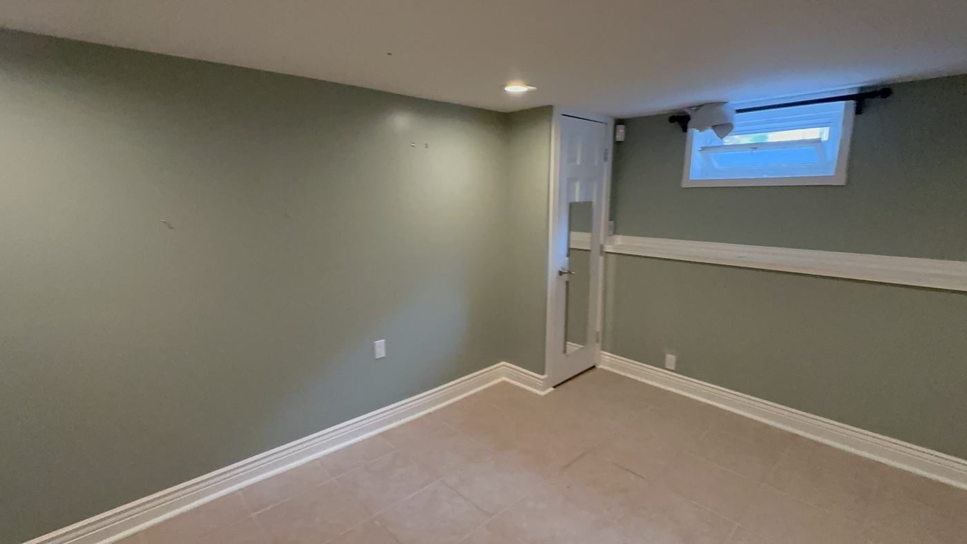 Family room in soft sage with a white chair rail, baseboards and trim
