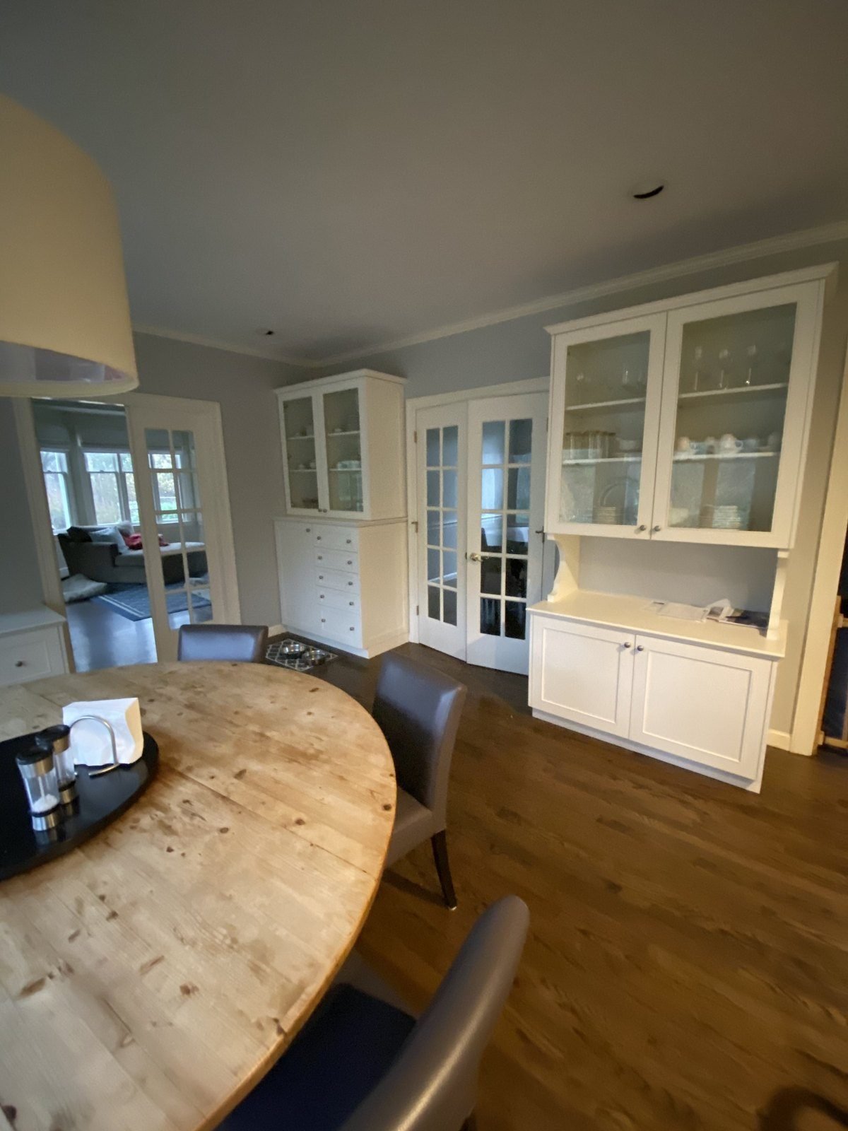 Dining area with a white built-in cabinet and glass doors freshly painted