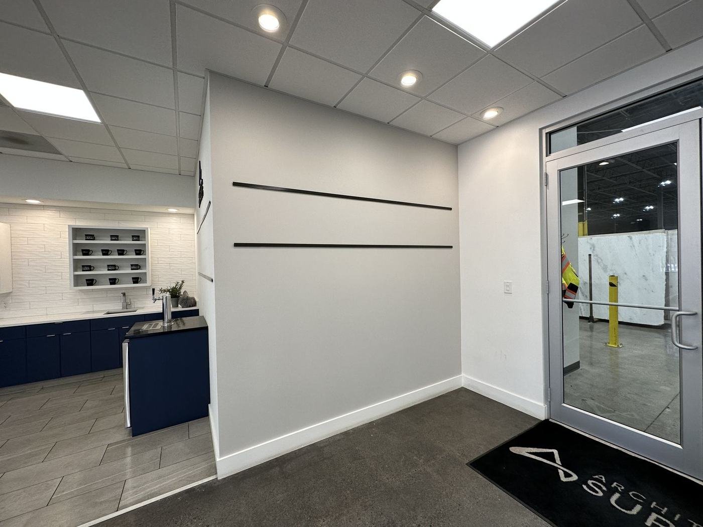 Modern kitchen and entry with navy cabinets painted by Painting Now