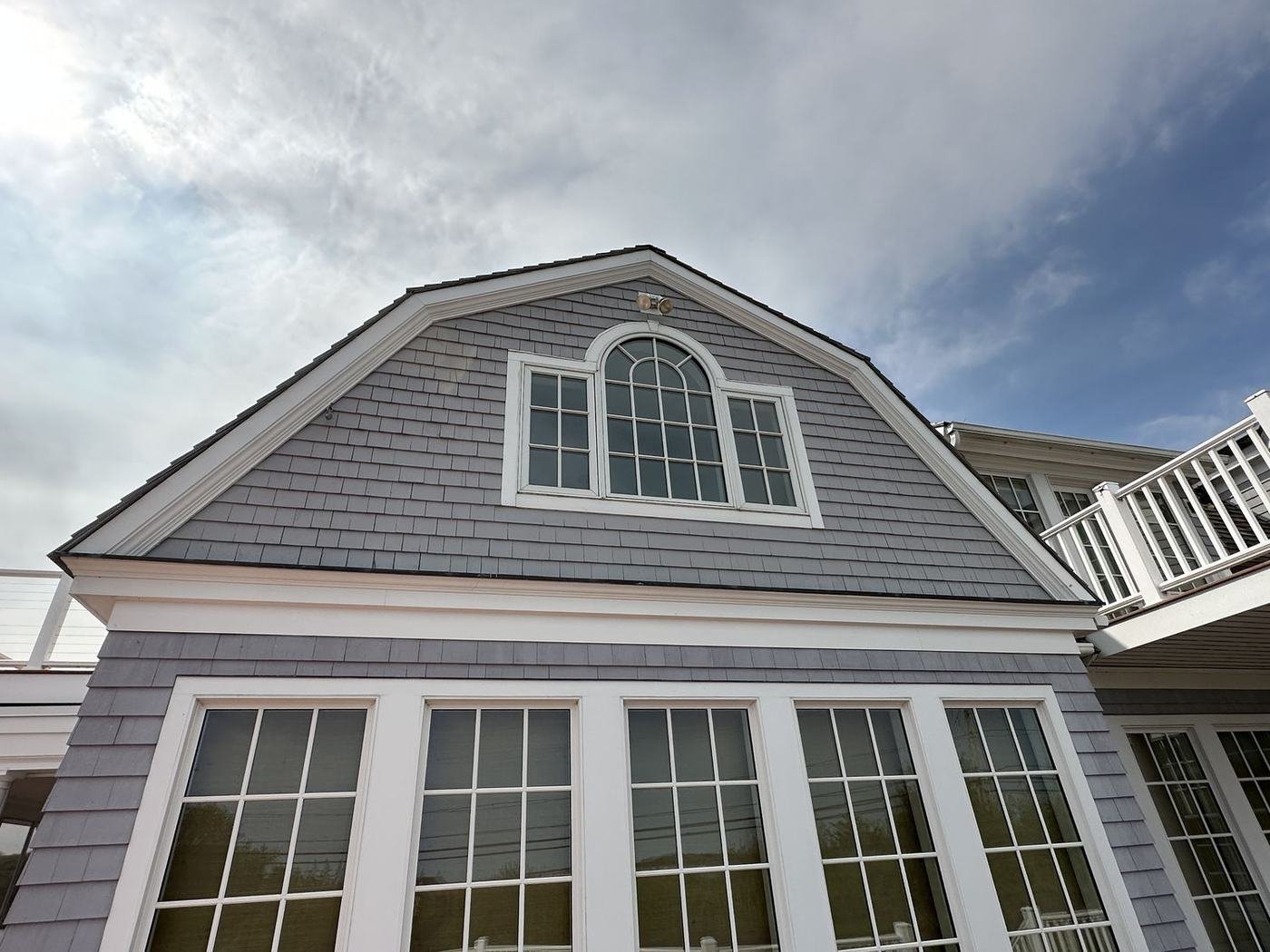 Gray gambrel-roof coastal home exterior painted by Painting Now
