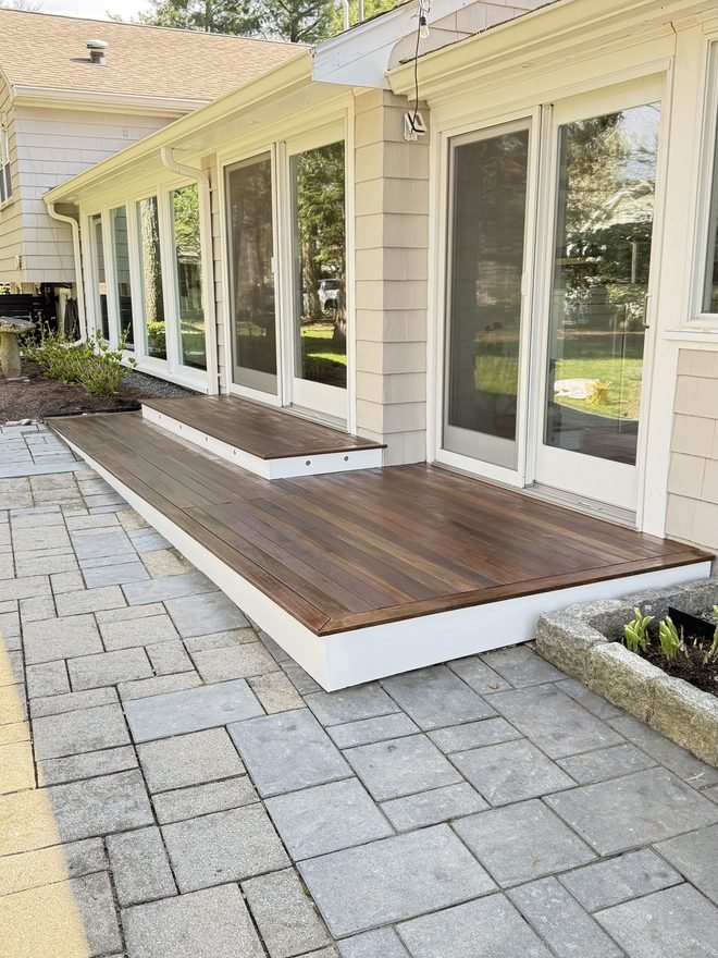 Covered porch with white painted columns and a mahogany deck