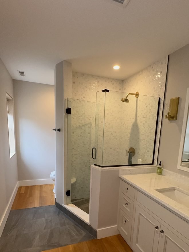 Master bathroom with a glass shower and a freshly painted white vanity
