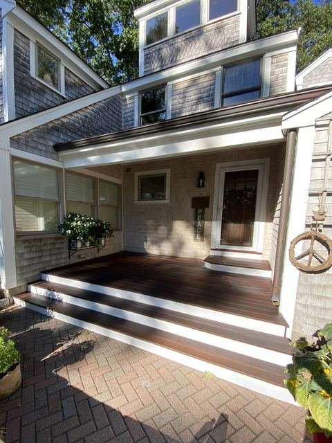 Coastal entry porch with white trim and dark deck