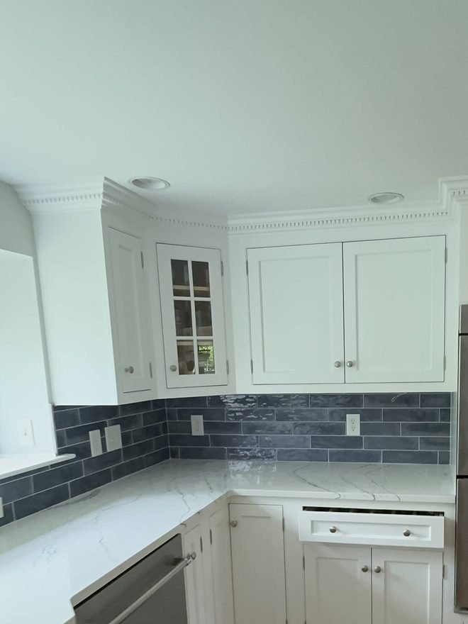 Kitchen with white shaker cabinets and a slate blue tile backsplash