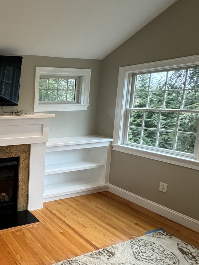 Living room with white built-in shelving and crisp painted window trim
