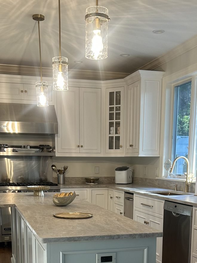 Refinished kitchen island in soft blue with white cabinetry behind