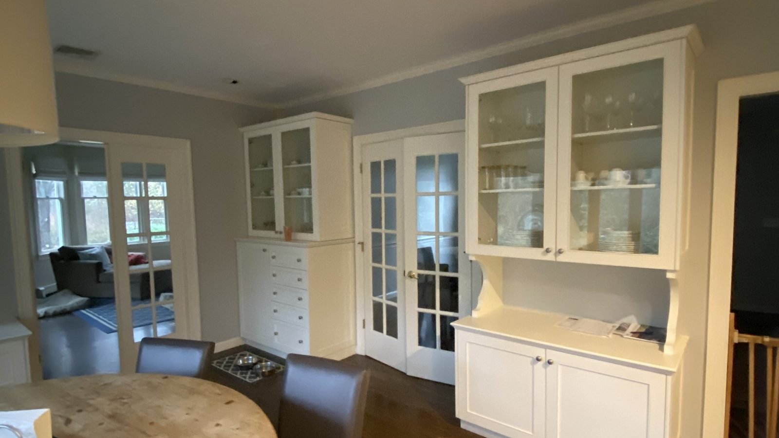 Dining room with two white built-in china cabinets and French doors freshly painted